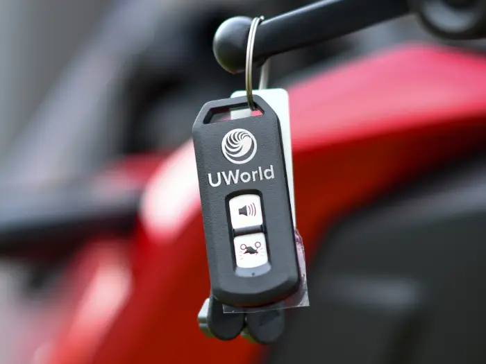 Man is handing keys over to a new motorcycle representing the “UWorld CFA test Drive”.